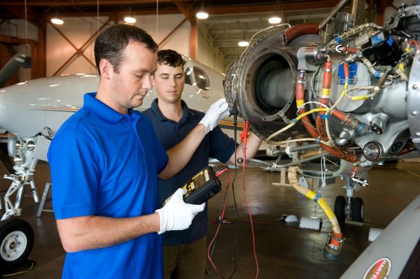Vector Aerospace technicians working on an engine